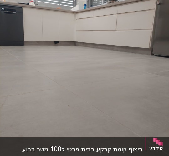 מטבח חדש עם ארונות לבנים ורצפת אריחים אפורה
